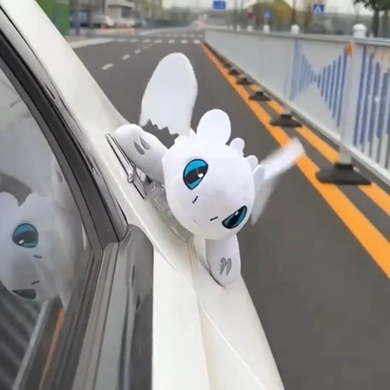 Cartoon plush dragon on the roof of a car