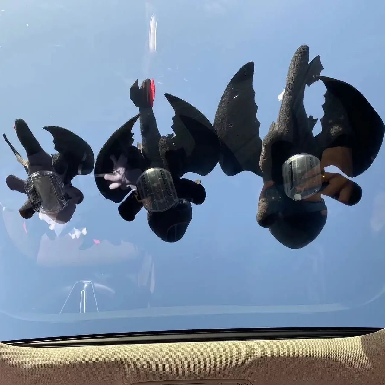 Cartoon plush dragon on the roof of a car