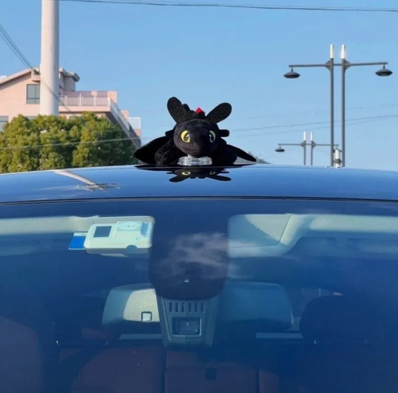 Cartoon plush dragon on the roof of a car